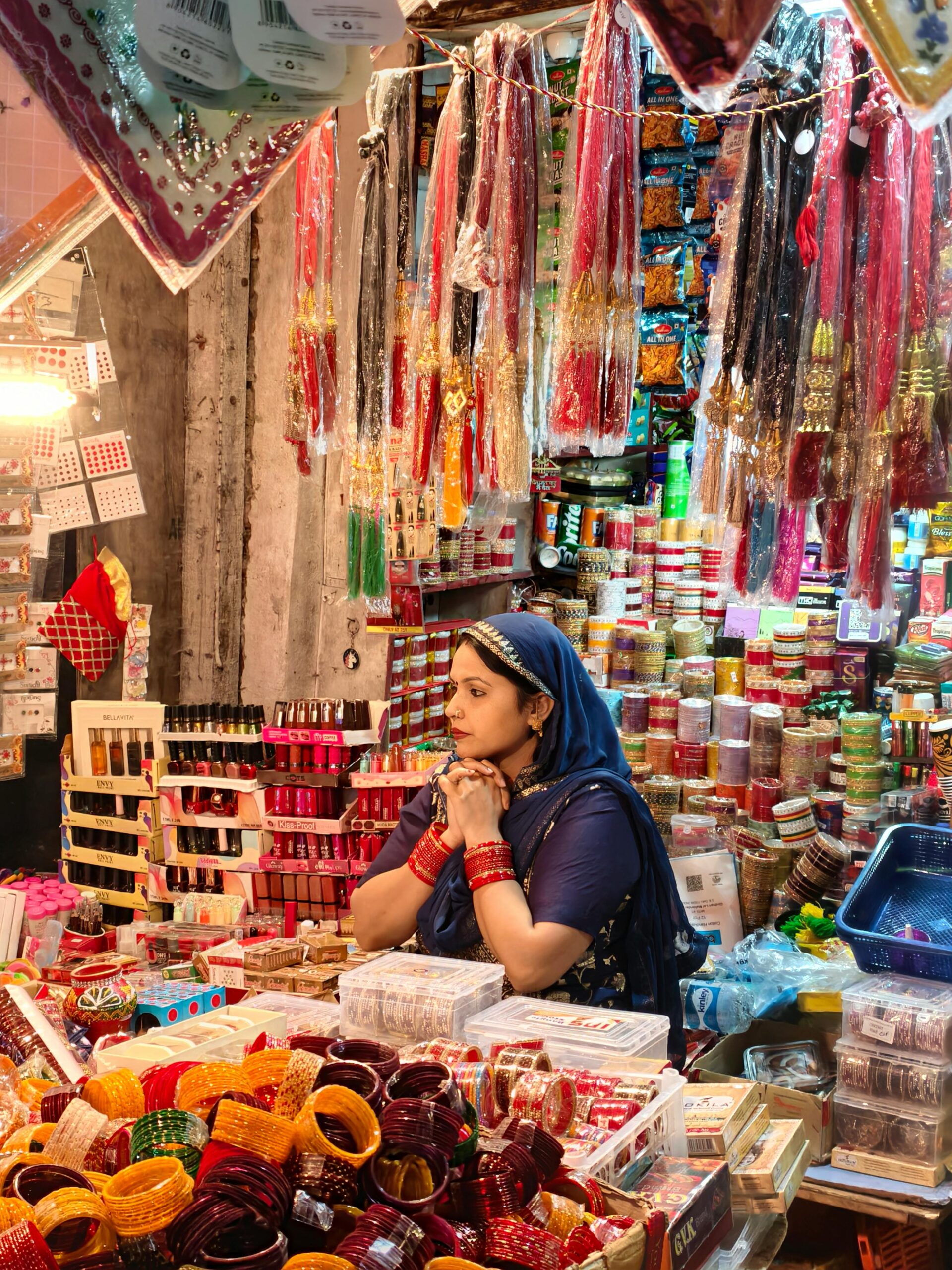 A vibrant market scene in India showcasing colorful bangles and a woman in traditional attire.